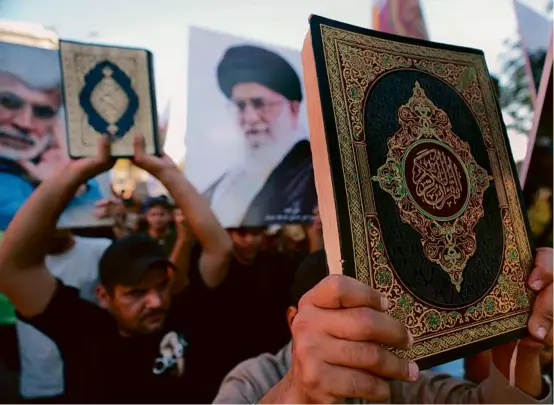  ?? HADI MIZBAN/ASSOCIATED PRESS ?? Iraqis raised copies of the Quran, Islam’s holy book, during a protest in Baghdad on Saturday.