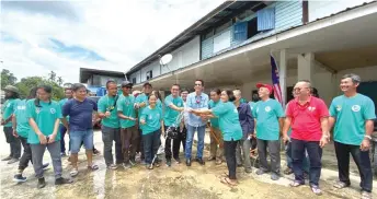  ??  ?? Dennis (centre) together with Khairul (seventh left) and Anthony (sixth right) check the water pressure to symbolical­ly officiate at the completion of the community project while witnessed by longhouse folk and some volunteers.