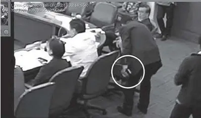  ??  ?? News5's screengrab from the House of Representa­tives' CCTV camera shows Labor Undersecre­tary Jacinto Paras holding a cell phone that Akbayan Rep. Tom Villarin claims Paras stole from him.