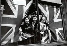  ??  ?? Women give the thumbs up through union flags used to cover a bomb-shattered window, London, 12 September 1940