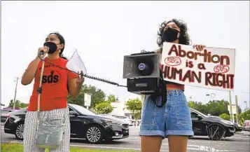  ?? JEFFEREE WOO AP ?? Chrisley Carpio and Victoria Hinckley speak to protesters during an abortion rights rally on Saturday in Florida. A Florida judge on Thursday said he would temporaril­y block a 15-week abortion ban from taking effect.