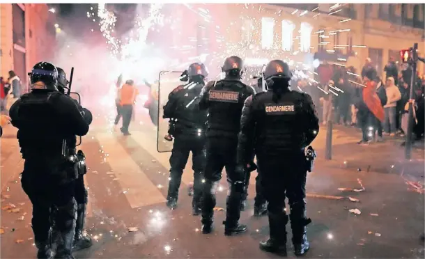  ?? FOTO: FRANCOIS MORI/AP ?? Polizisten stehen nach der Partie zwischen Frankreich und England auf den Champs-Elysées. Das Spiel gegen Marokko wird erneut brisant.