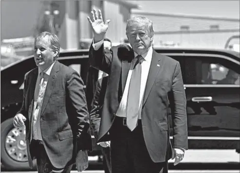  ?? NICHOLAS KAMM/GETTY-AFP ?? President Donald Trump waves next to Texas Attorney General Ken Paxton in Dallas on June 11.
