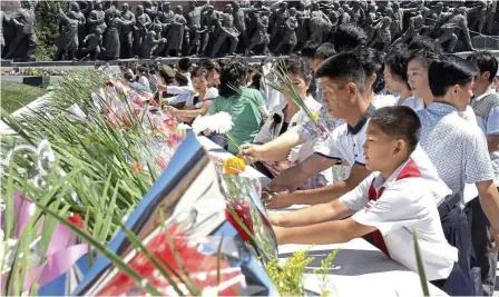  ??  ?? Public tribute: North Koreans laying flower bouquets on an altar before the statues of late leaders Kim Il-sung and Kim Jong-il at Mansu Hill in Pyongyang for the 21st anniversar­y of Il-sung’s death. — AFP