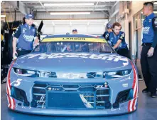  ?? JARED C. TILTON/GETTY ?? Crew members push the #5 Chevrolet, driven by Kyle Larson, out of the garage Friday. The NASCAR Cup finale is Sunday at Phoenix Raceway.