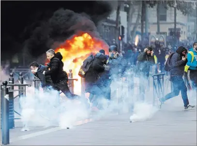  ?? Claude Paris The Associated Press ?? People flee Saturday as a car burns during clashes in Marseille, southern France.