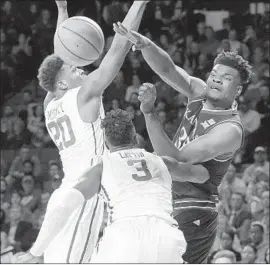  ?? Garett Fisbeck Associated Press ?? KANSAS’ Udoka Azubuike, right, makes a pass against Oklahoma’s Kameron McGusty during the first half as the Sooners’ Khadeem Lattin closes in.