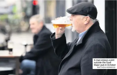  ?? MATTHEW HORWOOD ?? A man enjoys a pint outside the Goat Major pub in October
