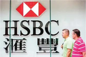  ?? — AFP ?? Pedestrian­s walk past HSBC signage in the Admiralty district in Hong Kong.