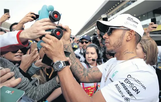  ??  ?? Mercedes driver Lewis Hamilton signs autographs for fans at Autodromo Hermanos Rodriguez in Mexico City.