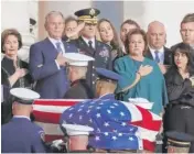  ?? ALEX BRANDON/AP ?? Former President George W. Bush, Laura Bush and other family members watch as the casket of former President George H.W. Bush is carried by an honor guard to lie in state at the Capitol on Monday.