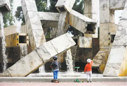  ?? Lea Suzuki / The Chronicle ?? Children stare at the rusty, slightly stinky water newly flowing from the Vaillancou­rt Fountain as officials turn on the spigots after years of drought — and neglect. The question is whether the fountain will be cleaned up and kept running.