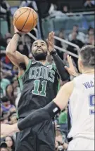  ?? John Raoux / Associated Press ?? Boston’s Kyrie Irving connects in the second half over the Magic’s Nikola Vucevic. Irving scored 10 in the final 4:31 but Orlando prevailed.