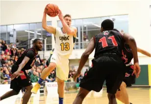  ?? CITIZEN PHOTO BY JAMES DOYLE ?? UNBC Timberwolv­es guard Vova Pluzhnikov drives to the basket against three University of Winnipeg Wesmen defenders on Friday night at Northern Sport Centre.