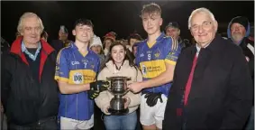  ??  ?? Caitlin Murray, on behalf of the Murray family, presenting the trophy to joint captains Ryan Culleton and Rian Stafford as John O’Neill (Coiste na nOg) and Brendan Furlong (People Newspapers) look on.