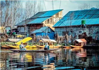  ??  ?? ung girl in a boat goes to school at Dal Lake