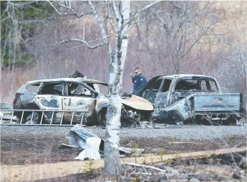  ?? Andrew Vaughan / The Canadian Pres ?? An RCMP investigat­or inspects burned- out vehicles at the home of murder victims Alanna Jenkins and Sean Mcleod,
both correction­s officers, in Wentworth Centre, N. S. A neighbour, Tom Bagley, was also killed on the property.