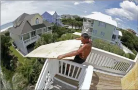  ?? TOM COPELAND—THE ASSOCIATED PRESS ?? Tim Avery pulls boards to the third story of a home as he prepares for Hurricane Florence at a home in Emerald Isle N.C., Wednesday.