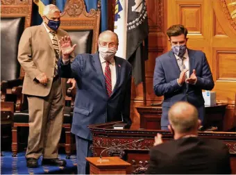  ?? MATT sTONE pHOTOs / HErALd sTAFF ?? FOND FAREWELL: House Speaker Robert DeLeo waves as his colleagues applaud before DeLeo’s farewell speech Tuesday in the State House. At left, Majority Leader Ronald Mariano, DeLeo’s likely successor, listens to the speech.