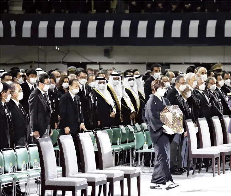  ?? Yomiuri Shimbun photos ?? Former Prime Minister Shinzo Abe’s wife Akie, center, holds Abe’s remains as she arrives at the venue for the state funeral at the Nippon Budokan hall in Chiyoda Ward, Tokyo, on Tuesday.