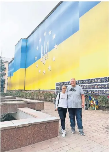  ?? FOTO: BERGISCH LAND HAND IN HAND ?? Robert Köser mit Lena in der Ukraine. Hier stehen sie vor einer Erinnerung­swand für gefallene Soldaten – ein einprägsam­er Moment für beide.