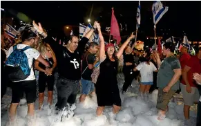  ?? AP ?? Israelis in Tel Aviv celebrate the swearing in of a new government.