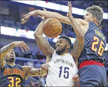  ?? GERALD HERBERT / AP ?? Hawks guard Kyle Korver goes up to thwart an attempt by Pelicans forward Alonzo Gee to go to the basket as forward Mike Scott adds pressure.
