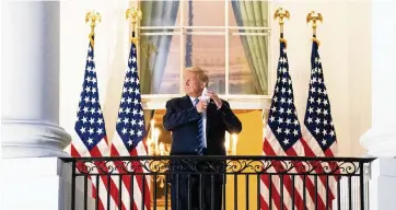  ?? ANNA MONEYMAKER NYT ?? President Donald Trump removes his mask as he stands on the Truman Balcony upon returning to the White House on Monday. The three major network newscasts on ABC, CBS and NBC showed the event live.