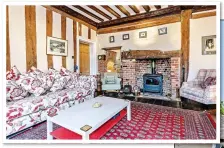  ??  ?? RICH HISTORY: The pink and timber facade of The Old Grammar School, right. Above: The cosy sitting room with its beamed ceiling