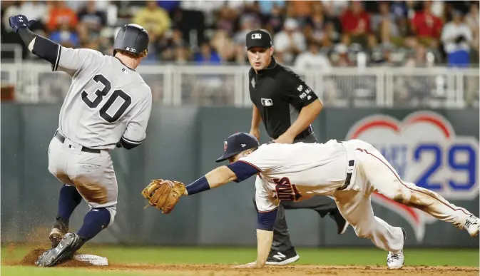  ??  ?? MINNEAPOLI­S: New York Yankees’ Clint Frazier beats the tag of Minnesota Twins second baseman Brian Dozier for a double during the eighth inning of a baseball game Monday, in Minneapoli­s. The Twins won 4-2. — AP