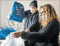  ?? ANDY LAVALLEY/ POST-TRIBUNE ?? South Haven firefighte­r Noah Allton helps Portage Township Trustee Deputy Chief of Staff Joy Lundstrom load autism sensory kits.