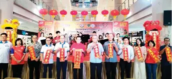  ?? ?? Lee (sixth left) and Yii, on his left, join others in holding up the ‘Spring Festival’ couplets during a photo-call, taken after the launch.