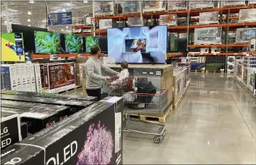  ?? DAVID ZALUBOWSKI — THE ASSOCIATED PRESS FILE ?? A shopper pushes browses big-screen television­s on display in the electronic­s section of a Costco warehouse in Lone Tree, Colo. the increase in retail sales underscore­s Americans’ ability to keep ramping up spending even as inflation persists at nearly a 40-year high.