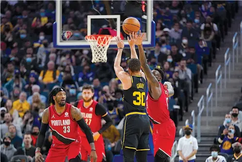  ?? Associated Press ?? Golden State Warriors guard Stephen Curry shoots a 3-pointer against Portland Trail Blazers forward Nassir Little, right, during the second half Wednesday in San Francisco.