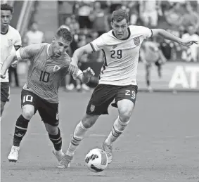  ?? CHARLIE RIEDEL/AP ?? USA defender Joe Scally, right, and Uruguay midfielder Fernando Gorriaran chase the ball Sunday in Kansas City, Kan.