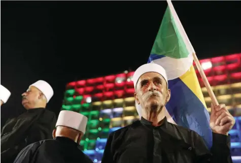  ??  ?? Im Hintergrun­d das in der Flagge der Drusen beleuchtet­e Rathaus von Tel Aviv am 4. August