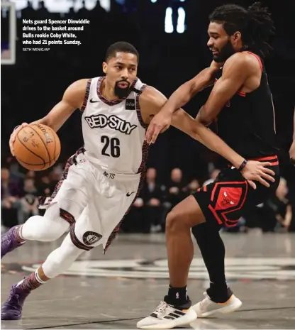  ?? SETH WENIG/AP ?? Nets guard Spencer Dinwiddie drives to the basket around Bulls rookie Coby White, who had 21 points Sunday.