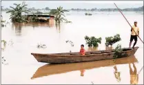  ?? PICTURE: REUTERS ?? A man and child on a boat on the flood-prone Brahmaputr­a River, which is said to be contaminat­ed with bacteria and iron.