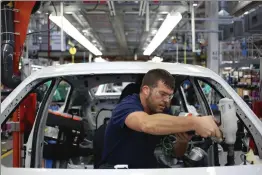  ?? Bloomberg photo by Luke Sharrett ?? An employee installs interior accessorie­s inside a BMW SUV on the assembly line at a BMW plant in Greer, South Carolina.