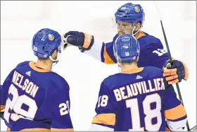  ?? FRANK GUNN — THE CANADIAN PRESS VIA AP ?? New York Islanders center Brock Nelson (29) celebrates his goal with teammates Anthony Beauvillie­r (18) and Josh Bailey (12) during the second period of an NHL Stanley Cup Eastern Conference playoff hockey game, Sunday, Aug. 30, 2020 in Toronto.