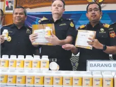  ?? Picture: LUKMAN BINTARO ?? Indonesian and Australian customs officials show off the haul of medicine that contains pseudoephe­drine.