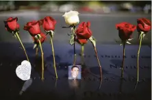  ?? Chip Somodevill­a / Getty Images ?? Flowers and photos are left in remembranc­e on the inscribed names of victims of the 9/11 terrorist attacks in New York City.