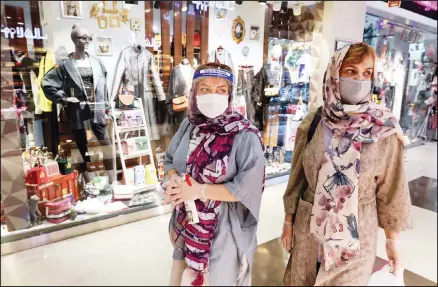  ?? (AP) ?? Women wearing protective face masks and gloves to help prevent the spread of the coronaviru­s shop at the Kourosh Shopping Center in Tehran, Iran,
Monday, April 20, 2020.