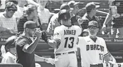  ?? GETTY IMAGES ?? Nick Ahmed gets fist-bumps from manager Torey Lovullo (17) and David Peralta after hitting a solo home run against the Dodgers during the fifth inning at Chase Field on Wednesday afternoon in Phoenix.