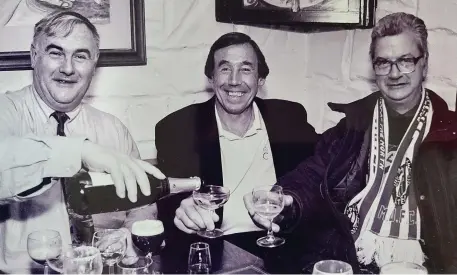 ??  ?? Bill Kirby pouring a glass of champagne for Gordon Banks and Seamus O’Mahony of Radio Kerry.