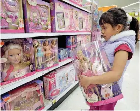  ??  ?? Yvette Ibarra holds a Dancing Princess Barbie doll while shopping at a Toys R Us in Monrovia, Calif.