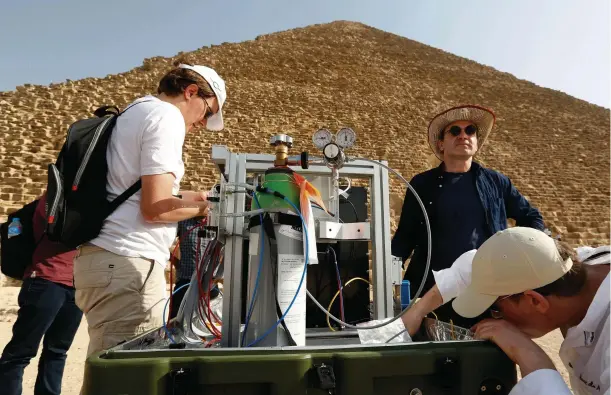  ??  ?? ABOVE
Some members of the ScanPyrami­ds team set up one of the project’s muon detectors in front of the north face of the Pyramid of Khufu