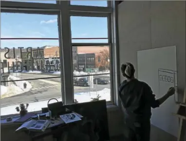  ?? BEN LAMBERT — THE REGISTER CITIZEN ?? Macayla Muzzulin gazes out at the city Thursday in the Launchpad studio space above the Five Points Gallery in downtown Torrington.