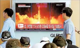  ?? AHN YOUNG-JOON/AP ?? South Koreans in Seoul tune in to the latest news about a North Korean missile launch.