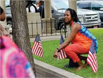  ?? (Caitlan Butler/News-Times) ?? Letitia Thrower poses for a photo above the brick memorializ­ing her father, QT Jackson, following the 2023 Community Wall unveiling ceremony on Thursday.